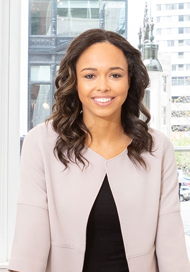 Professional woman smiling in modern office setting promoting real estate marketing services.