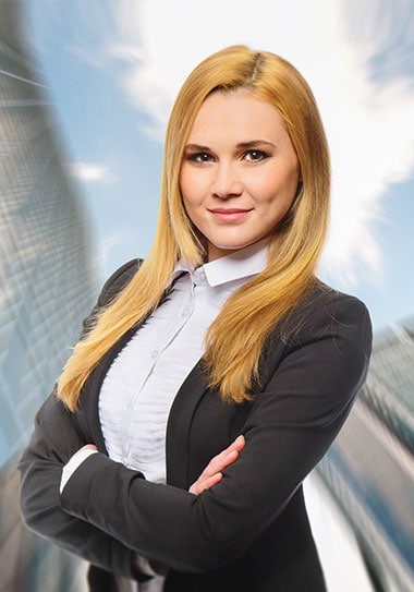 Confident businesswoman in a suit with modern city skyline background.