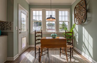 A kitchen with a table and chairs and green walls.