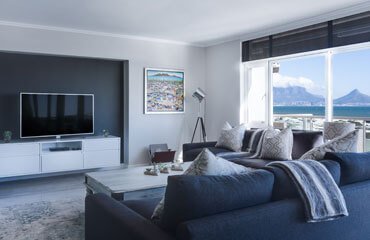 A living room with a view of the ocean.