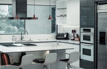 A modern kitchen with white cabinets and stainless steel appliances.